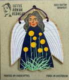 A wooden fairy ornament featuring billy button flowers
